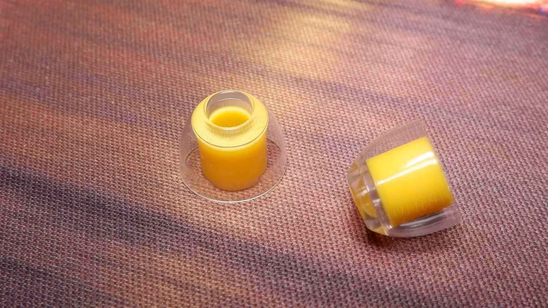 透明と黄色のイヤーチップが、布地の上に置かれている。