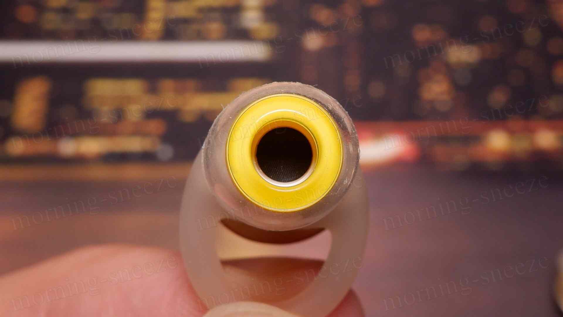 ノズル正面の図。黒い穴の内部が見える黄色いリングで囲まれた円筒形の物体。