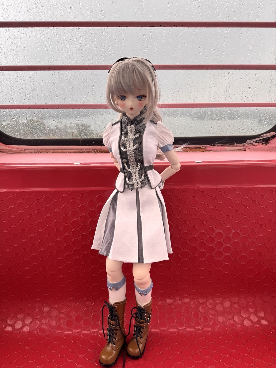 観覧車の赤い座席の上で立っているギンカ。窓は濡れてよく見えません。