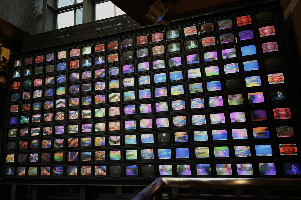 無数のテレビモニターが壁面に敷き詰められ、ランダムな画像を表示しているナム・ジュン・パイクの大規模インスタレーション