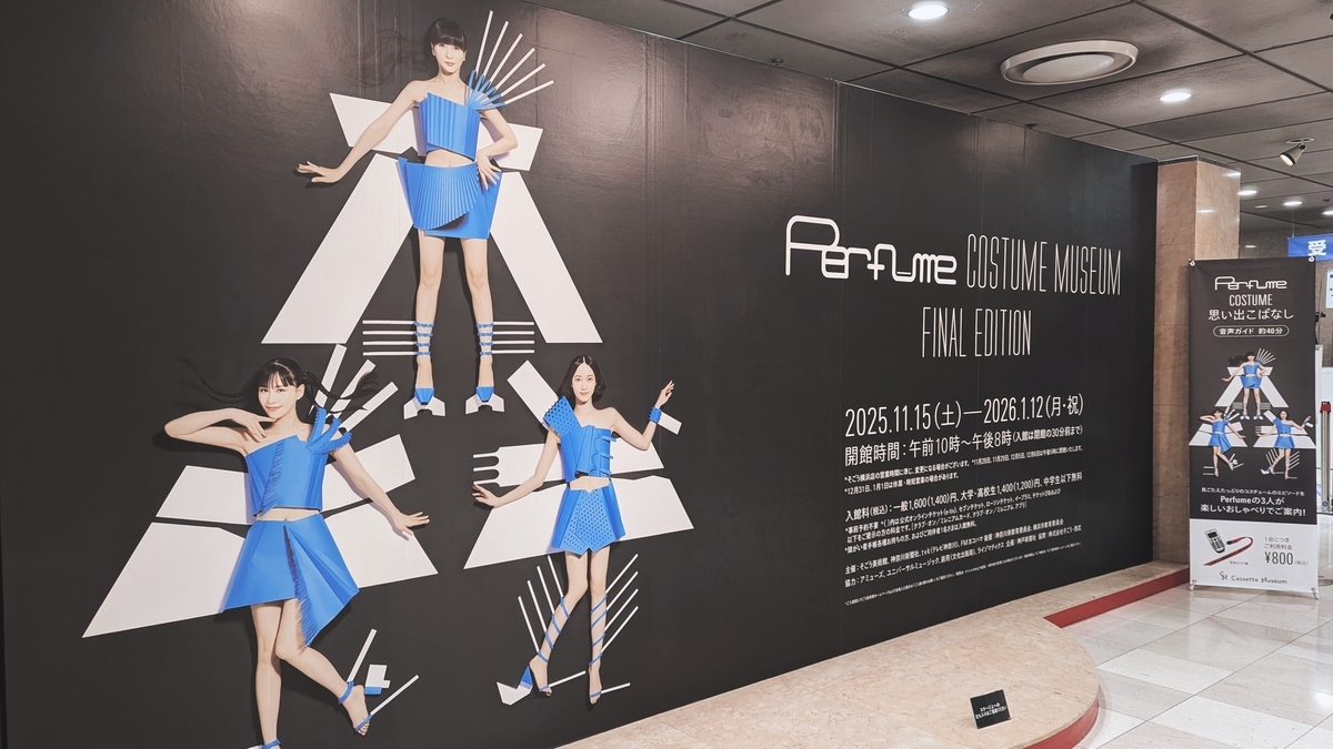 Perfume COSTUME MUSEUM FINAL EDITIONの告知パネル。黒い背景に青い衣装を着たメンバー3人の写真と、開催期間が記載。