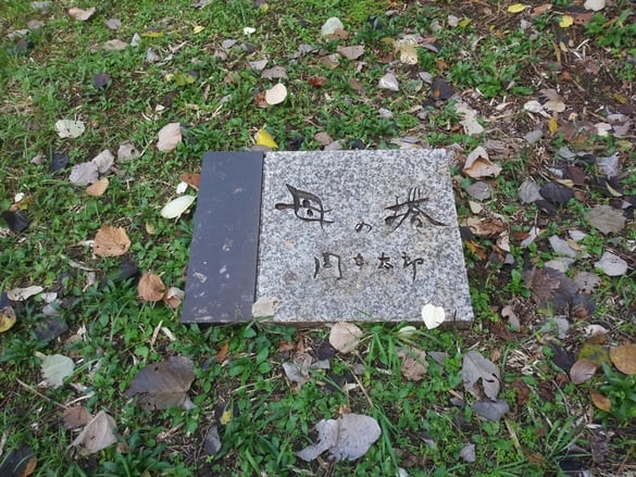 生田緑地紅葉　岡本太郎美術館母の塔　向かって左の地面に石碑がある