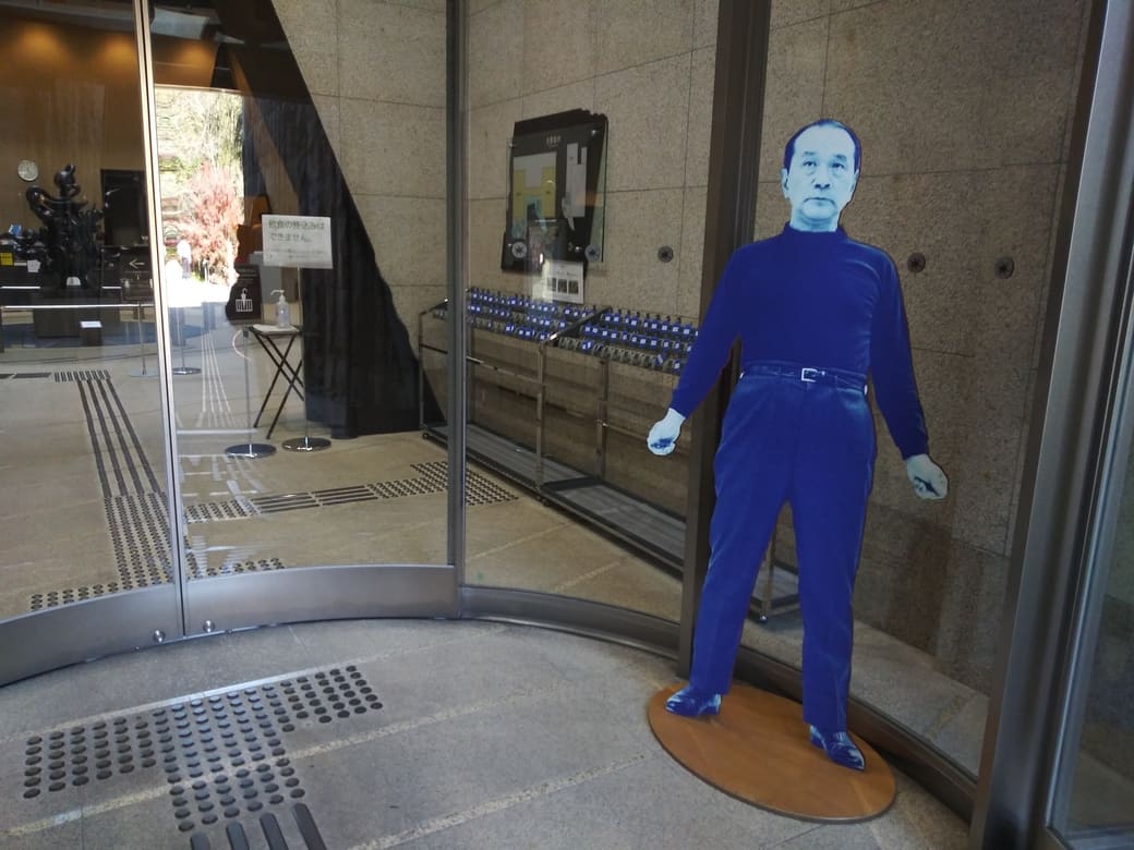 川崎市岡本太郎美術館　エントランスホール手前　岡本太郎の前身パネルが出迎えるかのように立っている