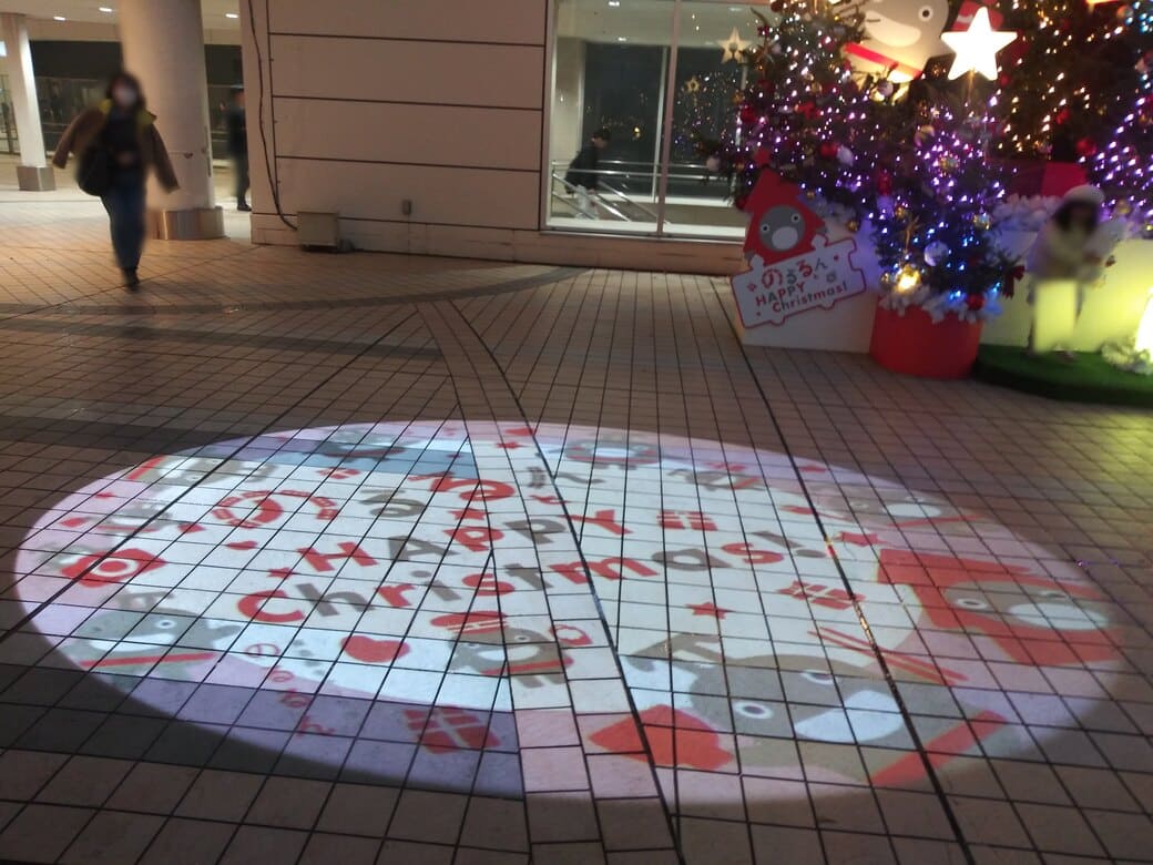 たまプラーザのクリスマスイルミネーション2025年_GATE PLAZA_ステーションコート_駅前のクリスマスツリー横にはロゴスポットライトが使われていた