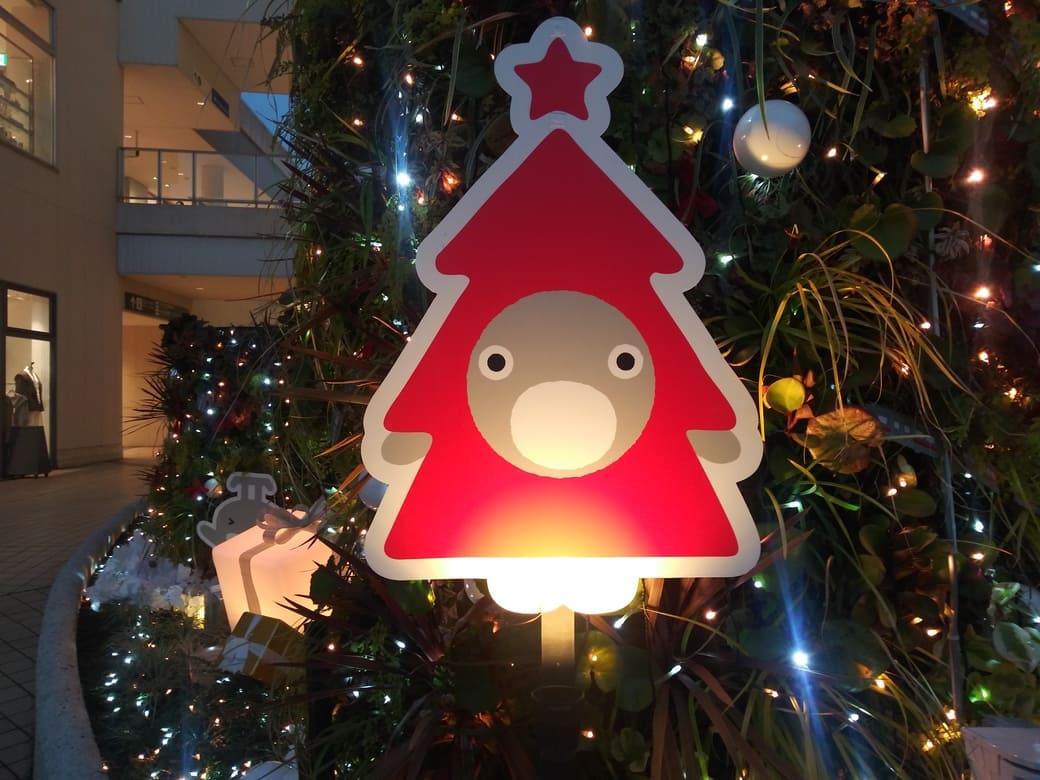 たまプラーザのクリスマスイルミネーション2025年_GATE PLAZA_交番側からカルディ方向への通路　赤いツリーをかぶったのるるんのオブジェ