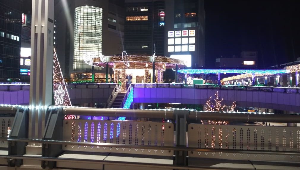 2025年第26回 溝口駅前 キラリデッキイルミネーション　キラリデッキの東急ストア側から見た円筒広場のライトアップ、ノクティ1，2を背景に