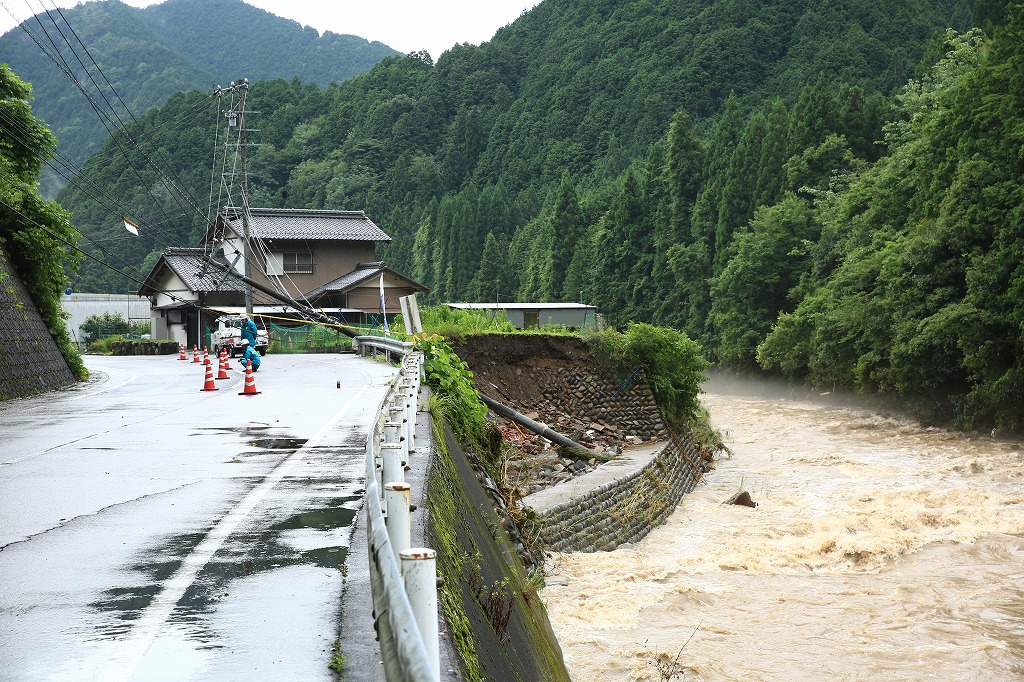 川べたの斜面が崩れ、電柱が道路に横たわった=関市上之保・川合地区で
