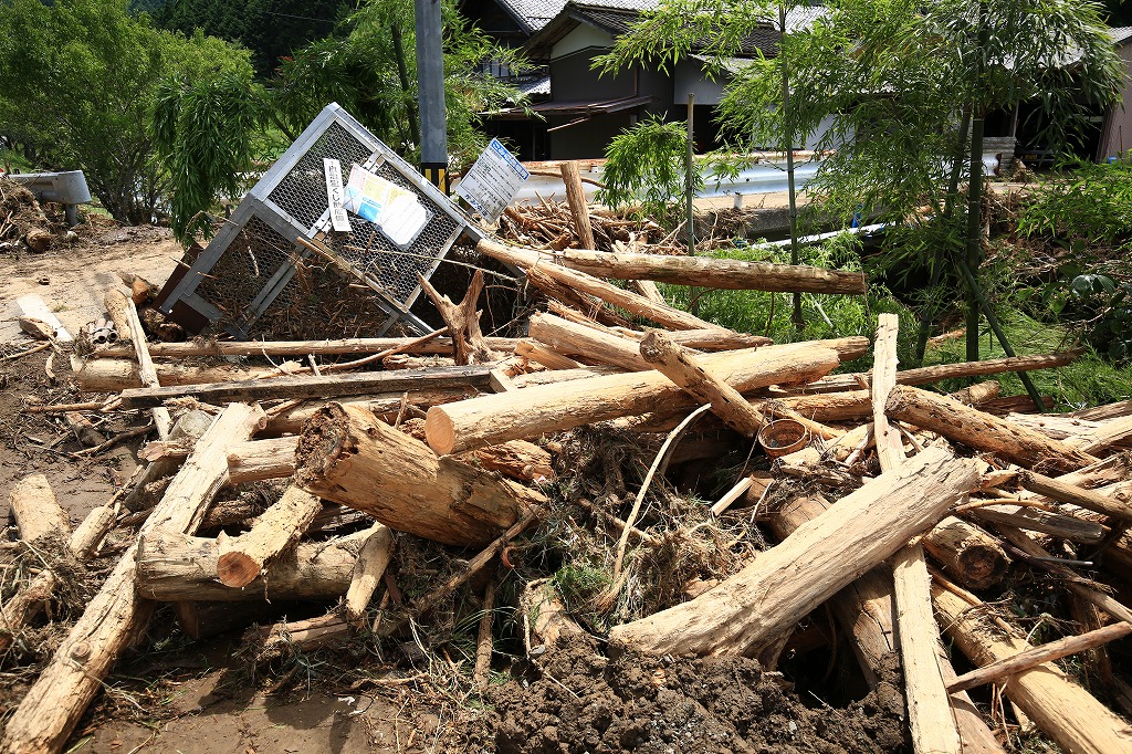 大木が押し流され、ごみ収集箱が盛り上がった=関市上之保・鳥屋市地区で