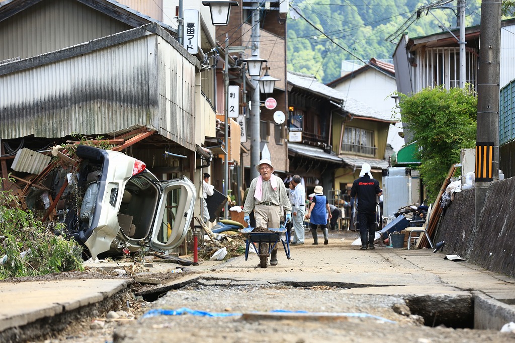 疲れ果てた表情で重労働の復旧作業に従事するボランティア=関市上之保で