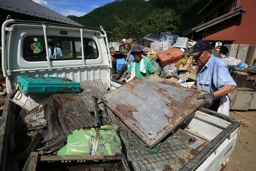 浸水した日用品を集積所へ運び出す=関市上之保で