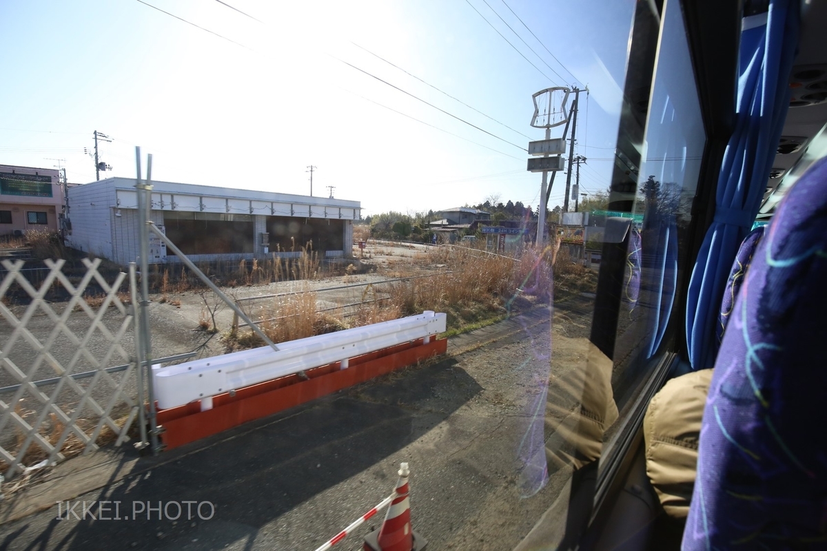 草が生い茂るコンビニ＝2019年3月 列車代行バス内で