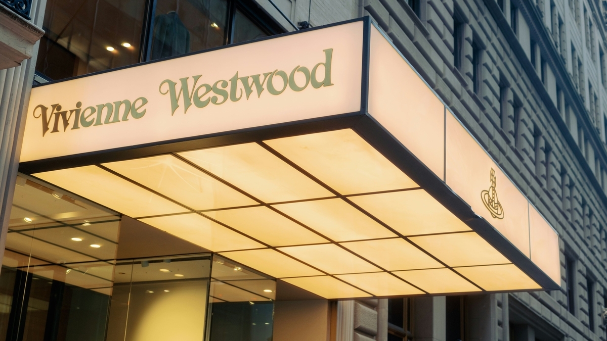 建物の入り口に設置された、Vivienne Westwoodのブランド名とロゴが記されたライトパネルの看板。格子状のデザインが施され、温かみのある光を放っている。
