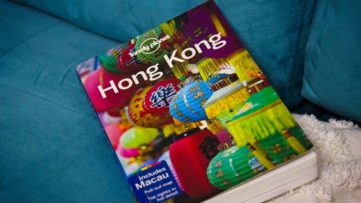 青いソファの上に置かれた、色鮮やかな提灯の写真が表紙の『Lonely Planet Hong Kong Includes Macau』というタイトルのガイドブック