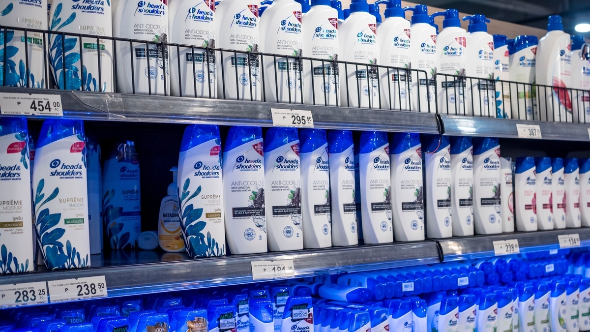 スーパーマーケットの棚に「head & shoulders」などのシャンプーやコンディショナーのボトルが隙間なく並べられた様子。