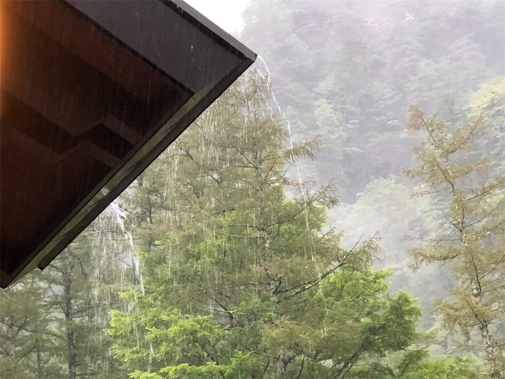 屋根から滝のように流れ落ちる雨。