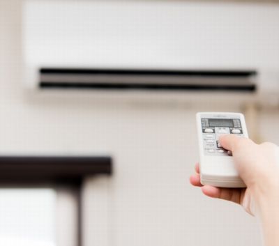 エアコンのリモコンを操作する手