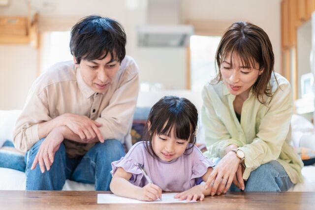 子供に両親が勉強を教え興味を持たせようとしている