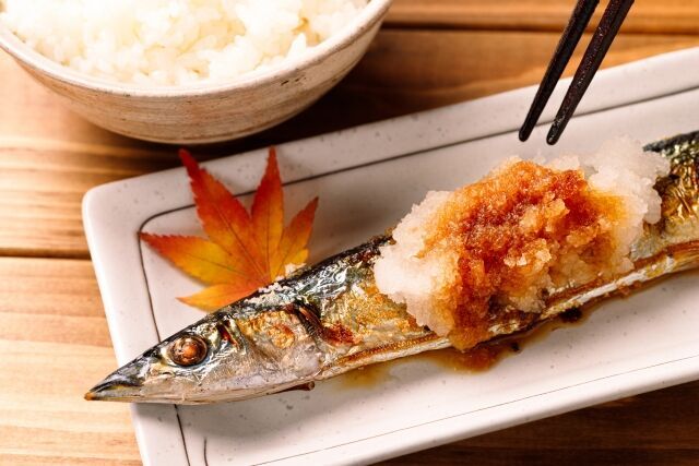 焼きさんまを大根おろしと一緒にお皿においしそうに盛る