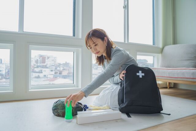 必要なものを防災バックに入れるママ