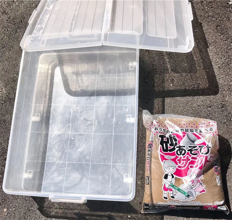 自宅で衣装ケース砂場を作るために用意した遊び専用の砂と蓋つき衣装ケースの写真