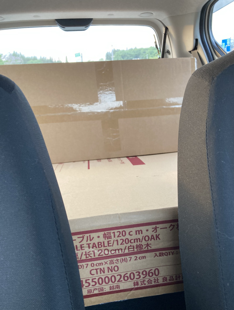 写真:ピクシスエポックの中、運転席と助手席の間から積み込んだテーブルと椅子の箱が見える。