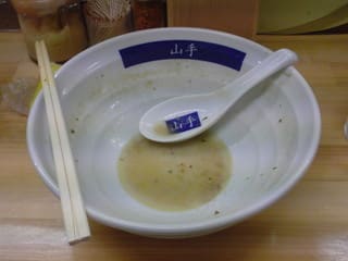 「みどりラーメン」を完食した後のラーメン丼と割り箸・散蓮華の写真