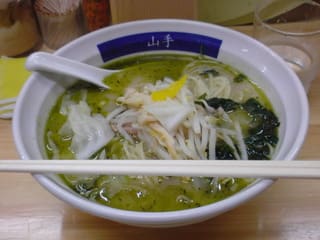 「みどりラーメン」の写真。鮮やかな黄緑色のスープに、麺・モヤシ・メンマ・レタス・ワカメが入っている。