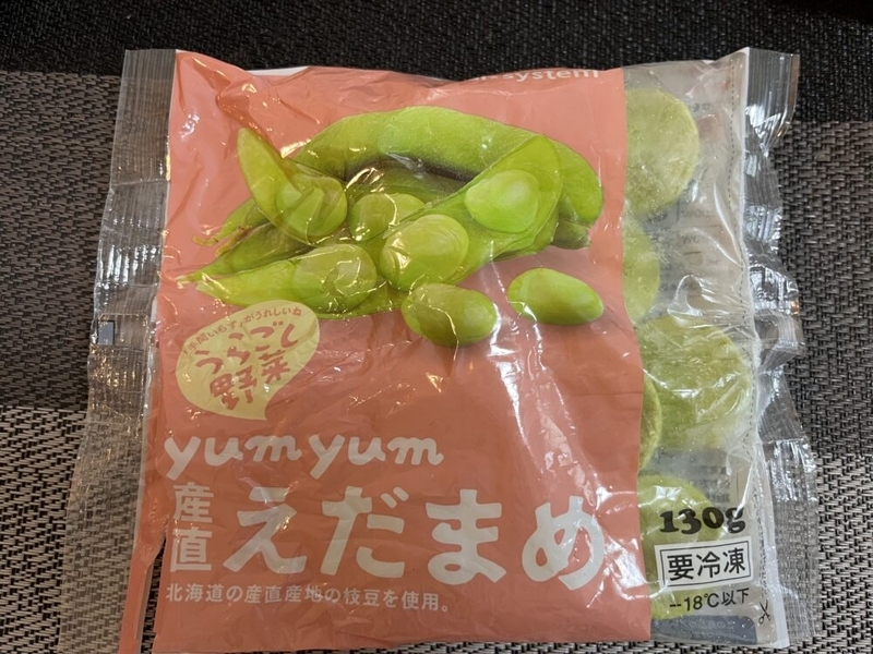 机に置かれたパルシステムのyumyum産直えだまめ。袋が少し開いている。