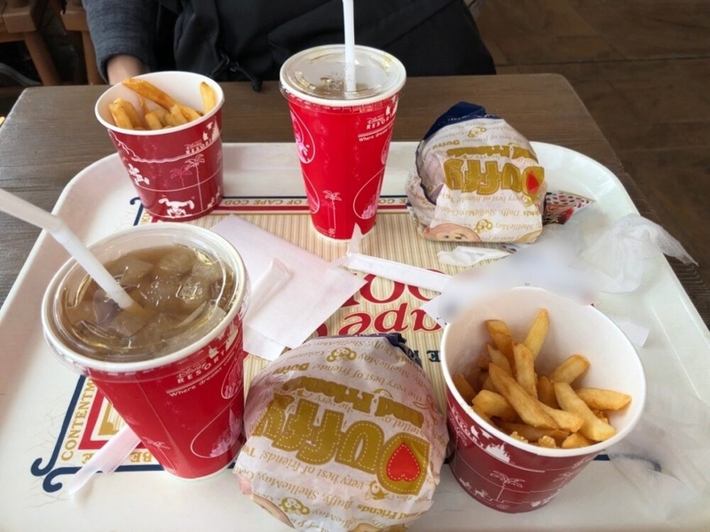 ハンバーガー、ポテト、飲み物が二人分テーブルの上にのっている。