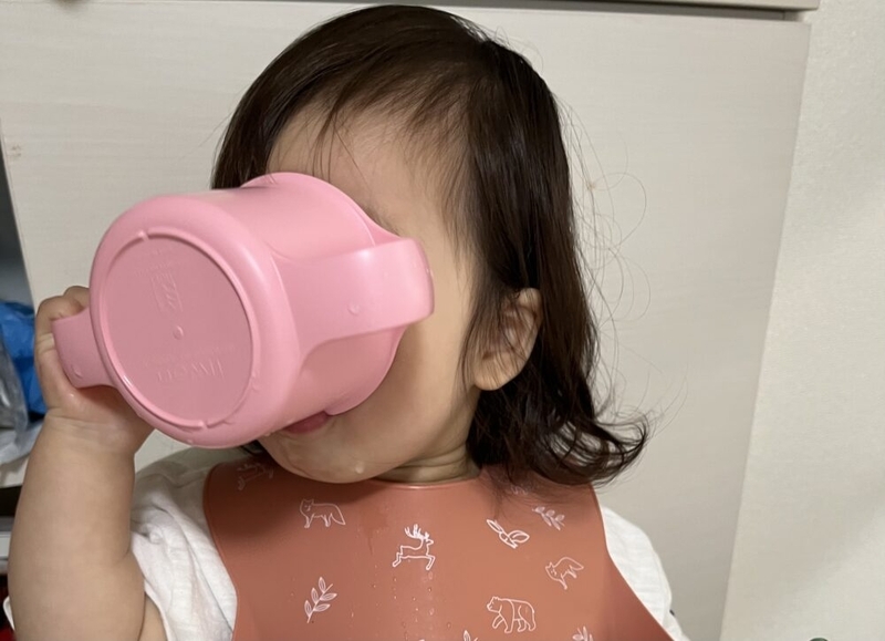 コップで水を飲む女の子