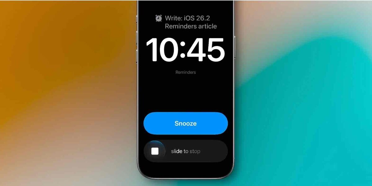 iPhoneの画面に“Write: iOS 26.2 Reminders article”というリマインダーのアラーム通知が表示されている様子。画面中央に時刻10:45とスヌーズボタンが見える