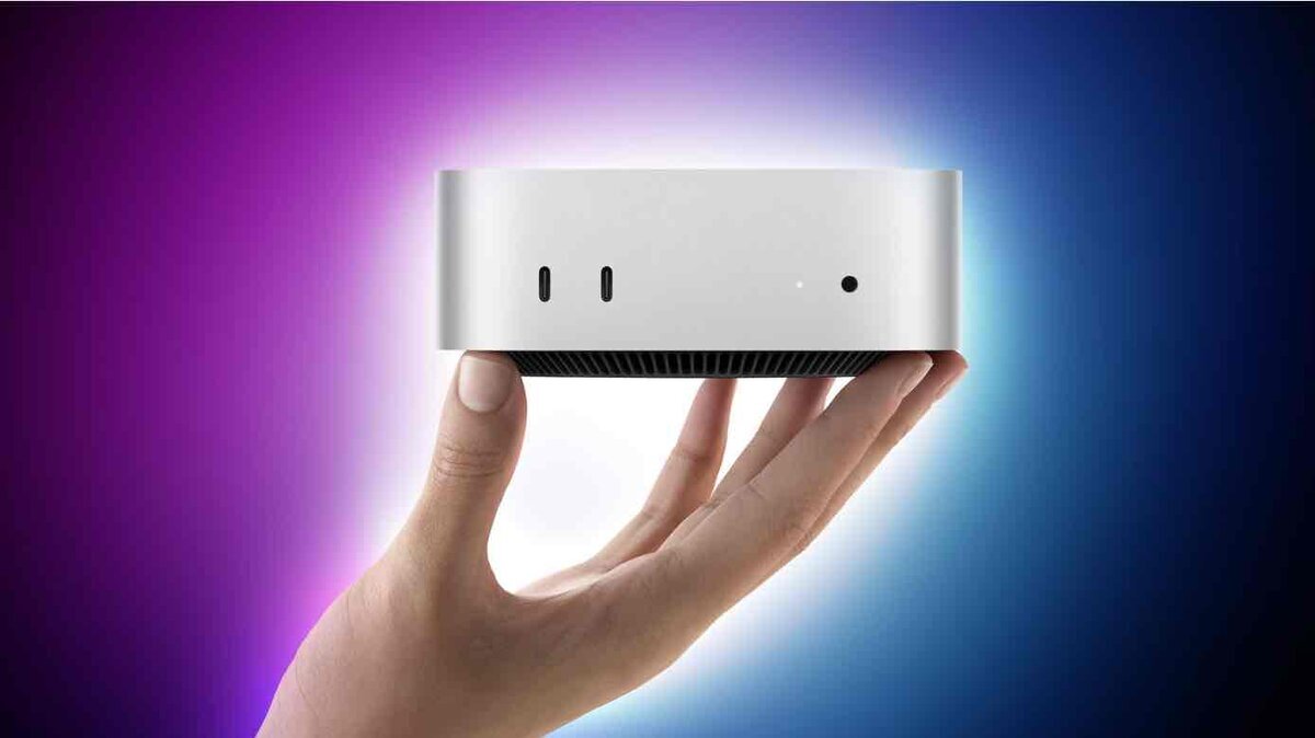手のひらに載せられたMac miniの正面カット。背面に紫と青のグラデーションライトが広がるイメージビジュアル