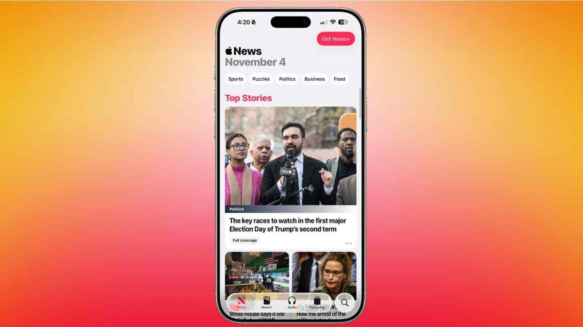 iOS 26.2のApple Newsアプリ画面。iPhoneのディスプレイに「Top Stories」などの見出しが表示され、政治ニュースのサムネイルが大きく掲載されている様子。背景はオレンジからピンクのグラデーション