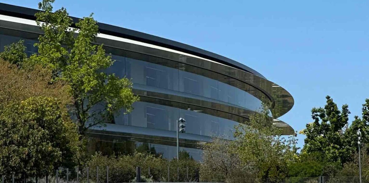 Apple Park本社の円形ビル外観。ガラス張りの建物と周囲の木々が映る様子