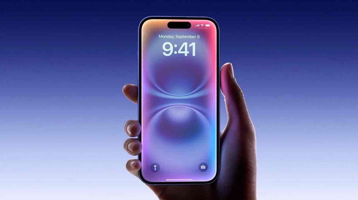 iPhoneのロック画面を片手で持って表示するイメージ。カラフルなLiquid Glass風の壁紙が映っている