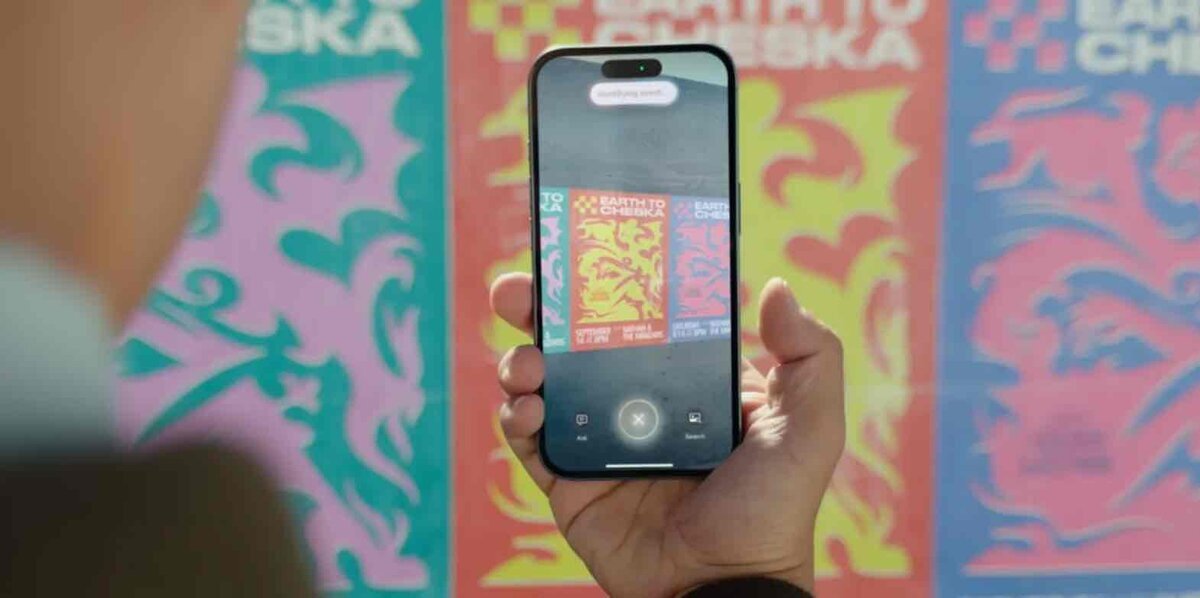 カラフルなポスターを前に、iPhoneでビジュアル検索のような機能を使ってポスターを読み取っている様子