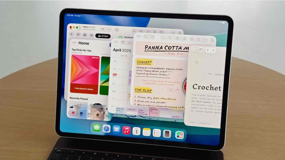 複数のアプリウィンドウを重ねて表示できるiPadOS 26の新しいマルチタスク画面を、キーボード付きiPadで使用している様子。