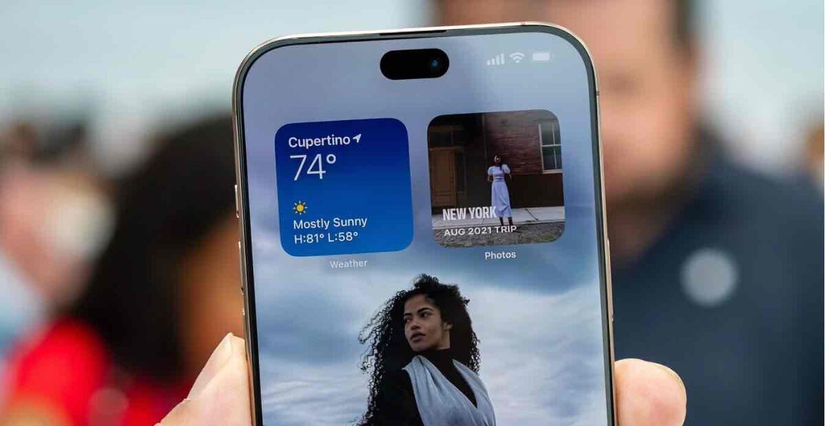 Dynamic Islandを表示しているiPhoneの前面イメージ。天気ウィジェットと写真アプリのアクティビティが画面上部に表示されている様子