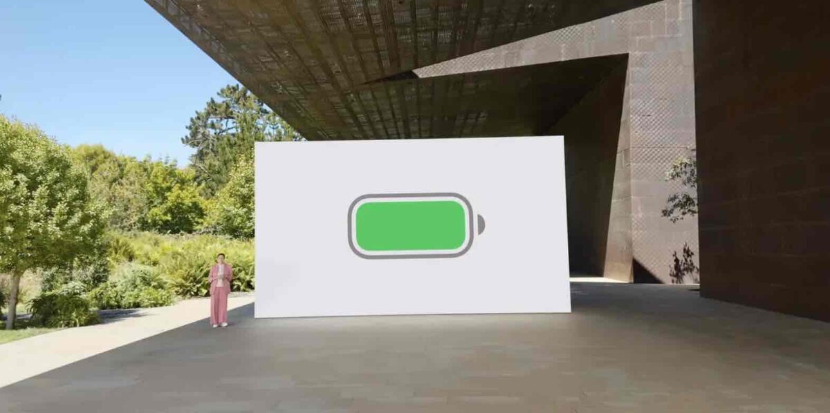 Apple Parkの屋外ステージで、大型スクリーンに緑色のバッテリーアイコンが表示されている様子。左側にプレゼンターが立っている