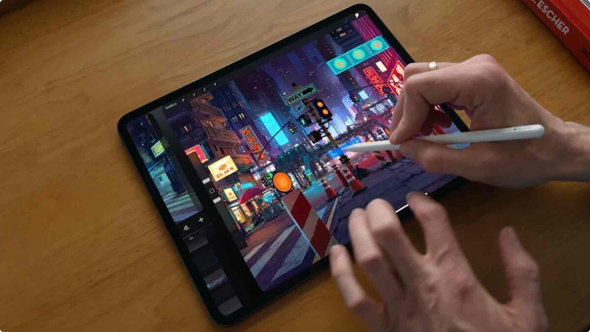 12.9インチiPad Proの画面上で、Apple Pencilを使用してサイバーパンク風の街並みのイラストを制作している様子。画面にはペイントアプリ「Procreate」のUIが表示されている