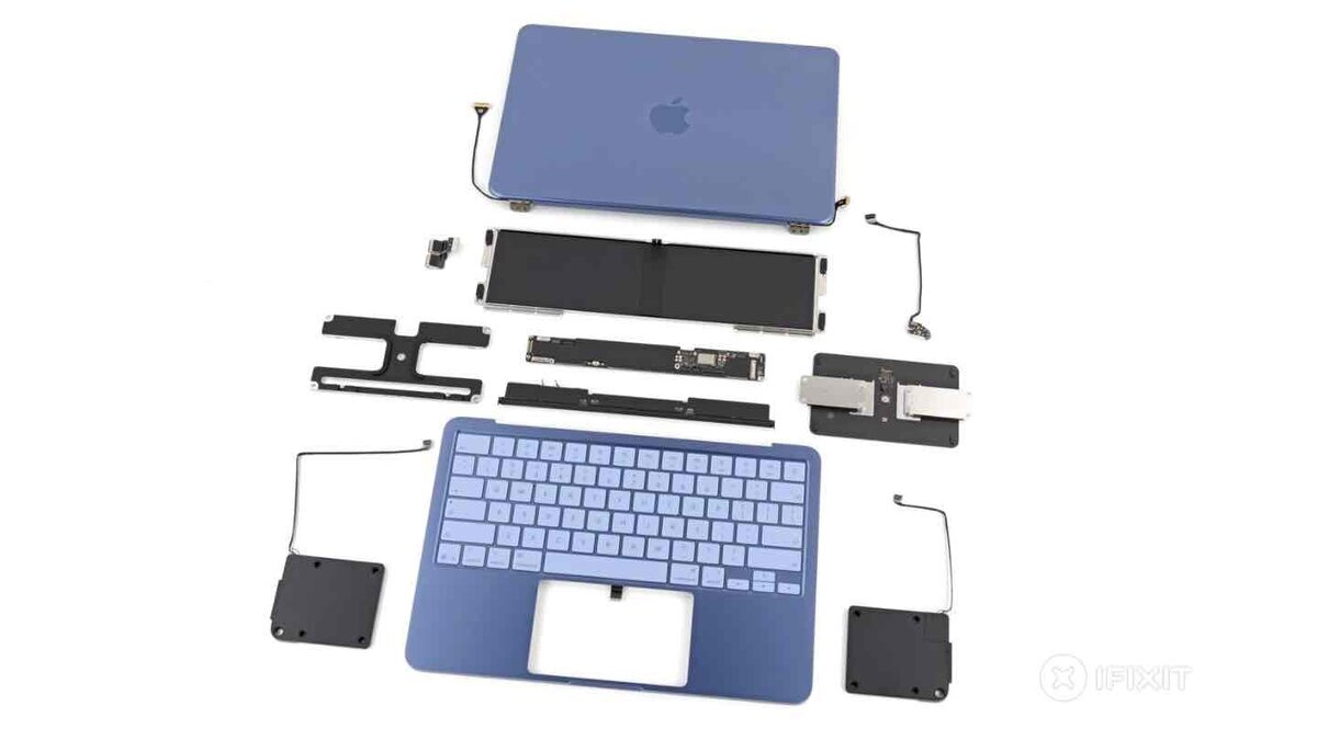 MacBook Neoの分解パーツ一覧。バッテリー、ロジックボード、スピーカー、キーボードなど主要部品を取り外して並べた内部構造