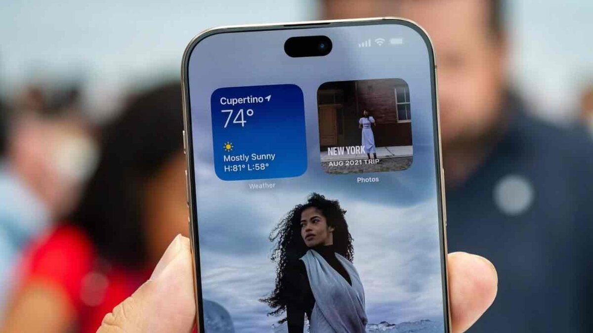 Dynamic Islandを搭載したiPhoneのホーム画面イメージ。天気ウィジェットと写真ウィジェットを表示
