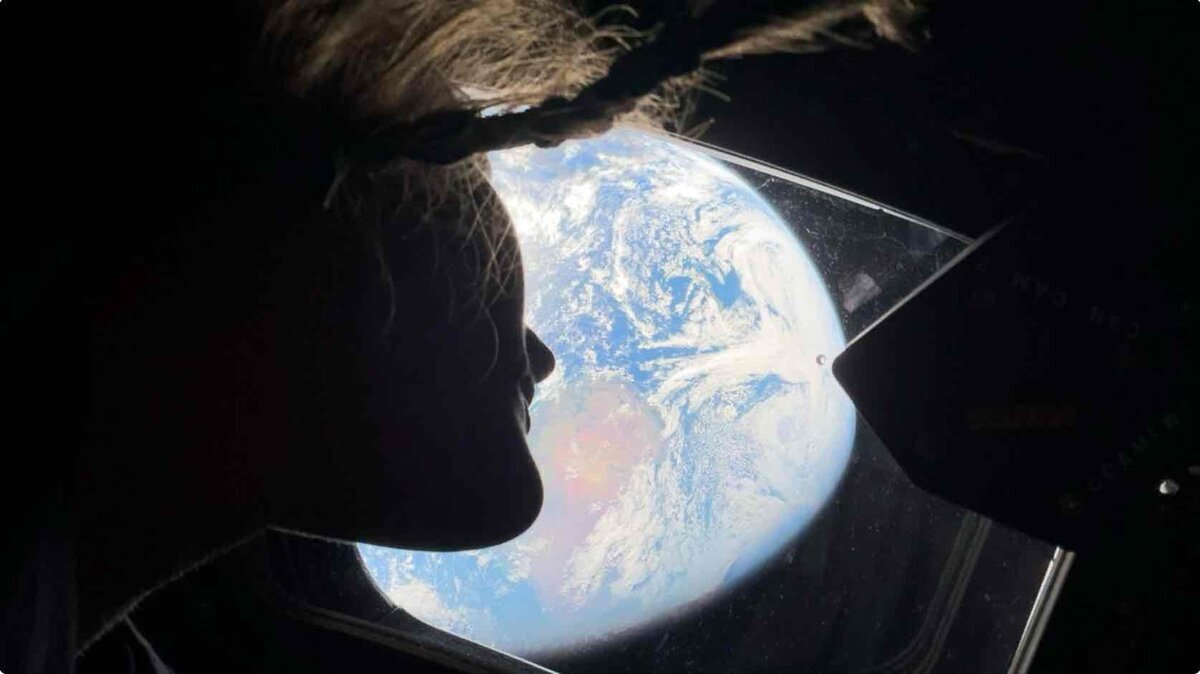 NASAアルテミスII宇宙飛行士がオリオン宇宙船の窓から地球を見つめるシルエット写真　iPhone 17 Pro Maxのフロントカメラで撮影された宇宙セルフィー