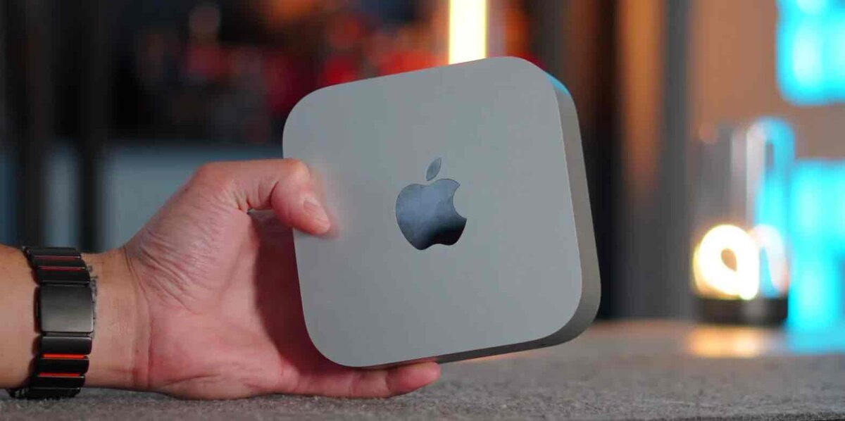 年内にM5 / M5 Proチップ搭載でリフレッシュが噂されるMac miniの本体を手に持った写真。正方形のコンパクトな筐体と中央のAppleロゴが、最小サイズのMacらしいミニマルな佇まいを見せている