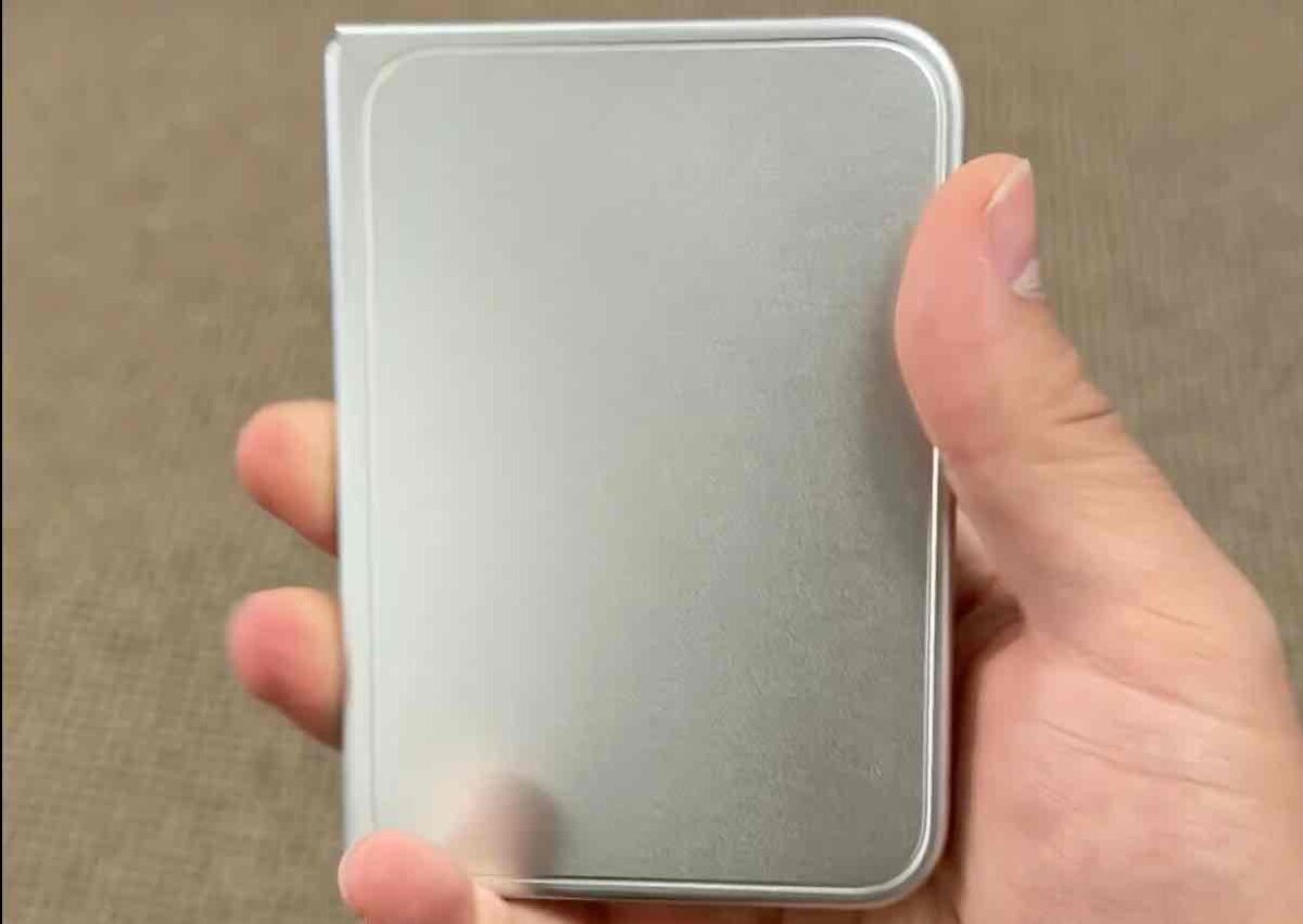 折りたたみiPhone Ultraのダミーモデルを閉じた状態で手に持ち、片手でのサイズ感と厚みを示す写真