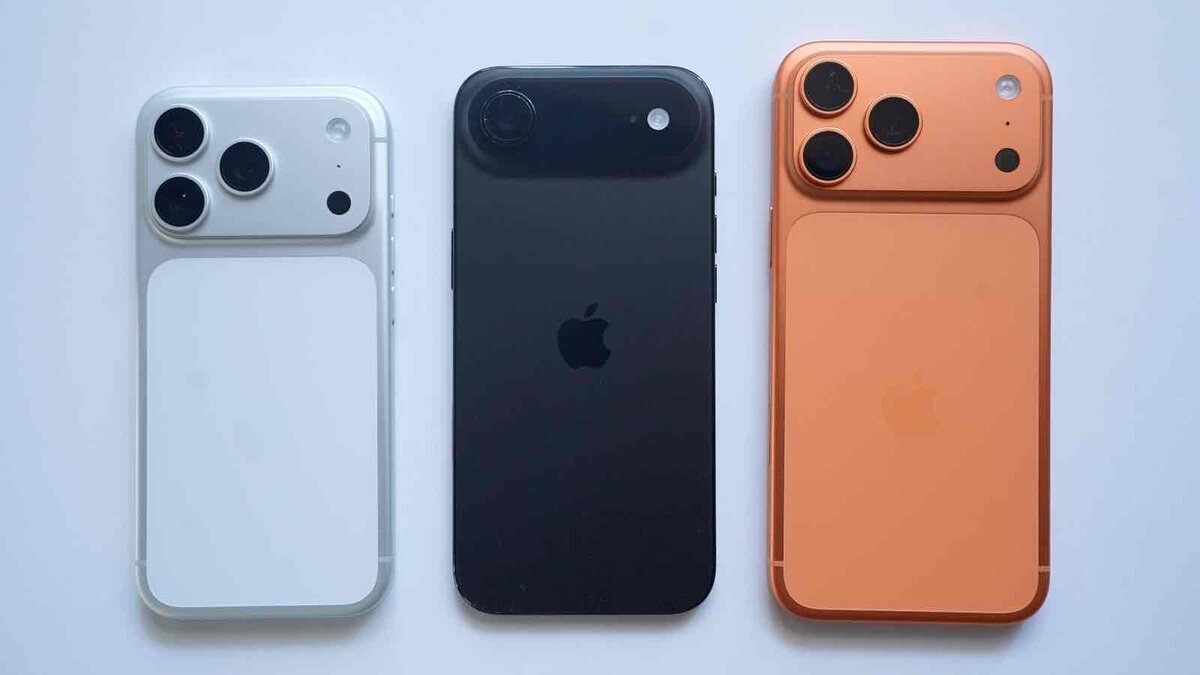 白、黒、オレンジの3台のiPhone背面を並べた画像。左右は大型カメラユニットを備え、中央は黒いシンプルな背面デザインになっている