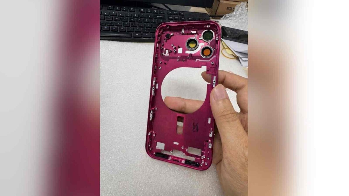 iPhone 18 Proのダークチェリー新色とされる筐体パーツを手に持ったリーク画像、カメラ穴と内部フレームが見える