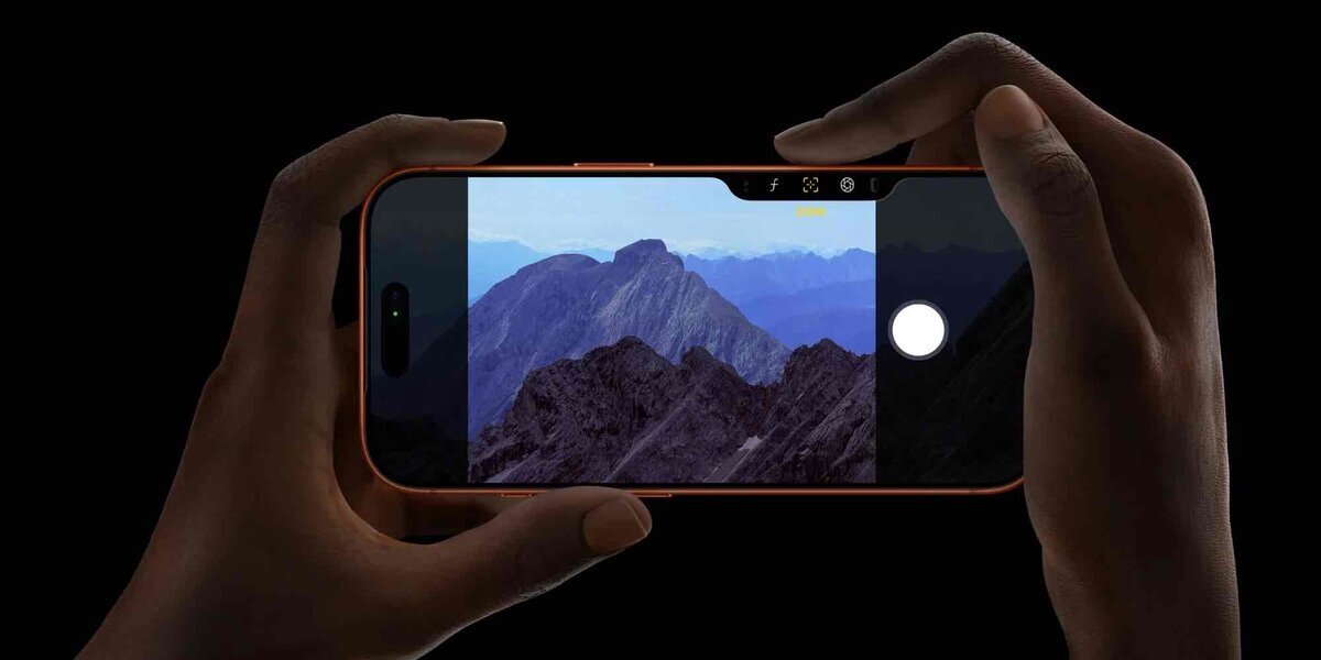iPhoneのカメラアプリで山の風景を横向き撮影している様子。画面上部に撮影設定アイコン、右側にシャッターボタンが表示されている