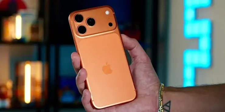 コズミックオレンジのiPhone 17 Proを手に持つ様子