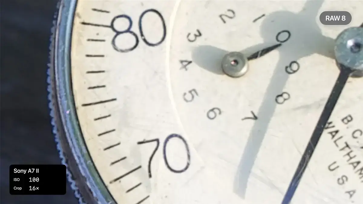 古い計器の文字盤を拡大した画像。80と70の数字や細かい目盛りが写り、RAW 8では輪郭がやや甘い。右上にRAW 8の表示